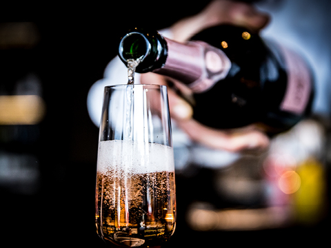 Glas wird mit Champagner gefüllt