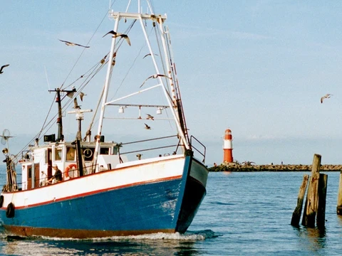Einfahrt eines Fischerboots in den Hafen