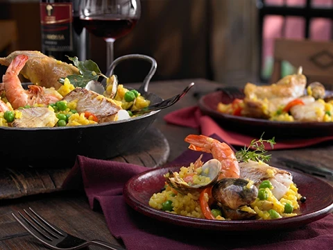 Gedeckter Tisch mit mehreren Tellern Paella